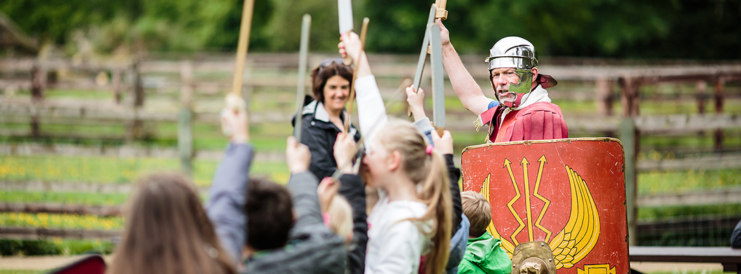 A Roman soldier holds his sword aloft, encouraging children to participate A Roman soldier holds his sword aloft, encouraging children to participate